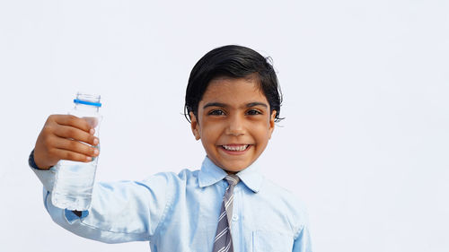 Portrait of young businesswoman standing against white background