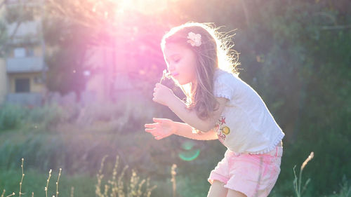 Girl standing against plants