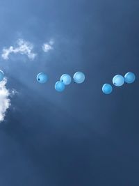 Low angle view of balloons against blue sky