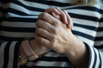 Midsection of woman with clasped hands