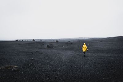 Rear view of person walking on land