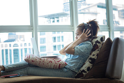 Woman sitting by window at home