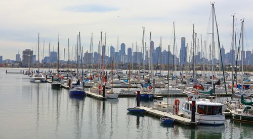 Boats moored at harbor against sky