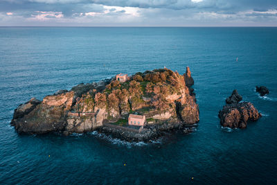 High angle view of rocks in sea against sky