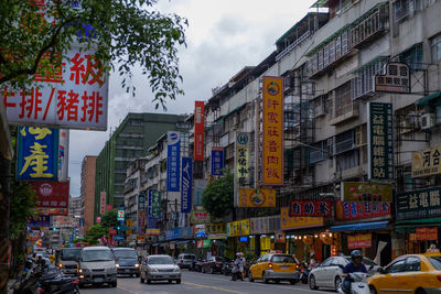 Cars on street against buildings in city