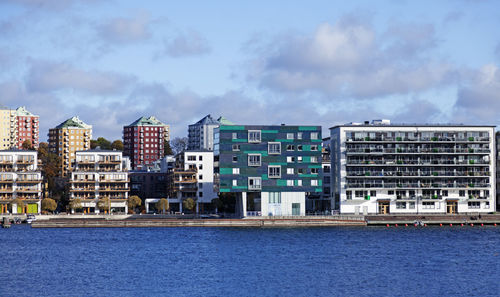 Buildings by sea against sky