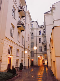 Low angle view of illuminated street amidst buildings in city