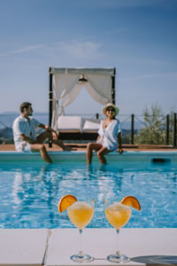 People at swimming pool against sky