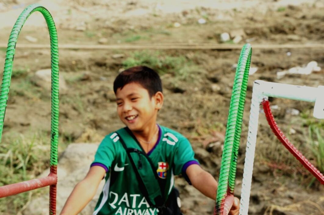 BOY HOLDING UMBRELLA IN FIELD