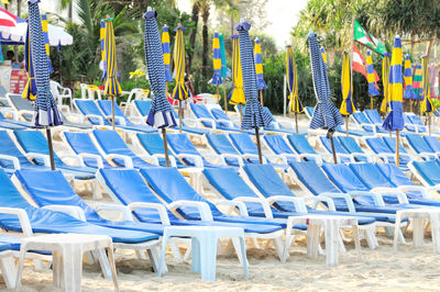 Closed parasols and deck chairs at beach