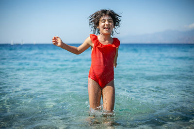 Portrait of young woman standing at beach
