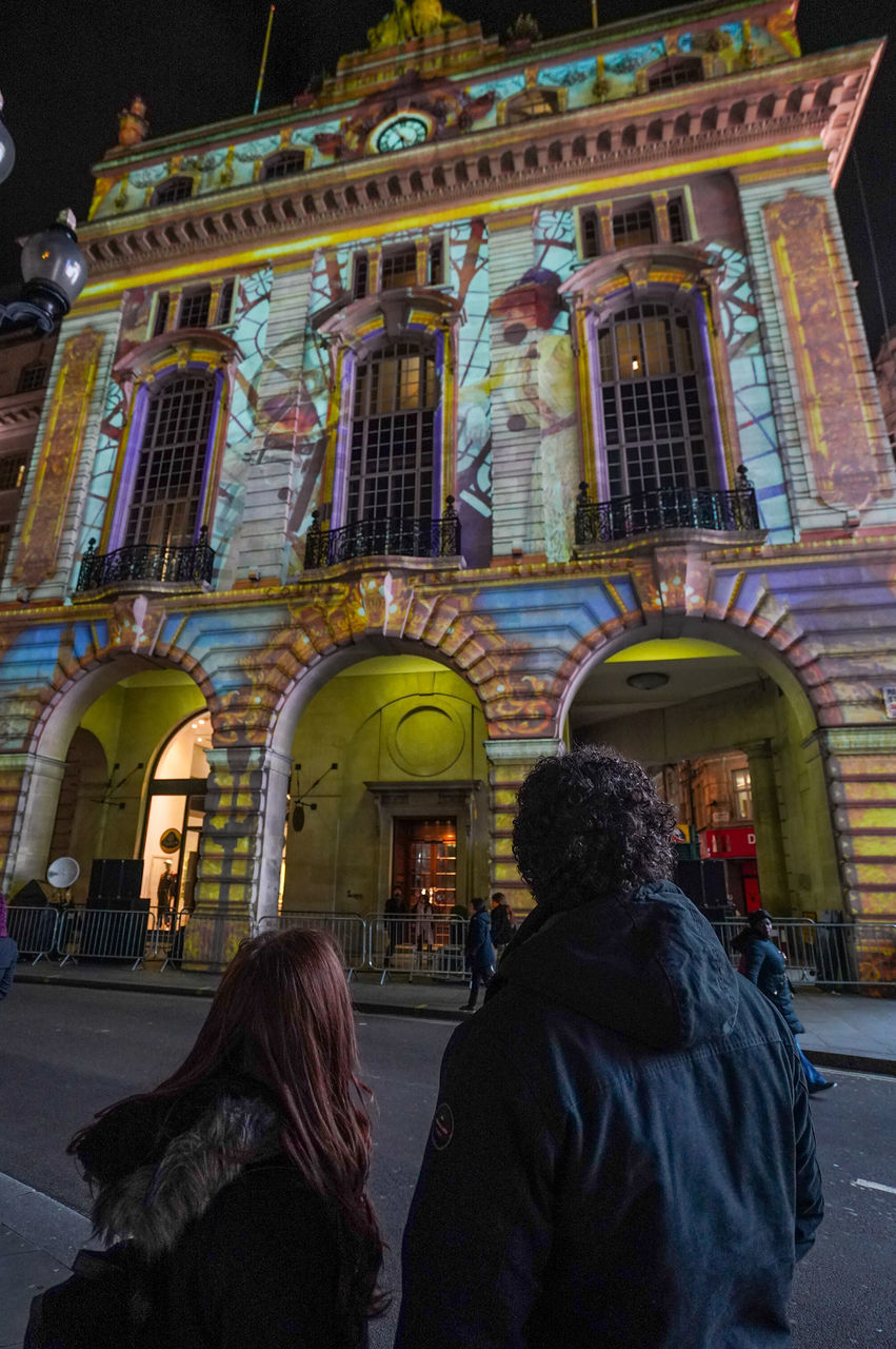 REAR VIEW OF PEOPLE AT TOWN SQUARE