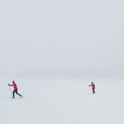 Hikers snowboarding on snow covered field