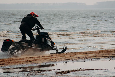 Sportsman on a snowmobile rides on the water