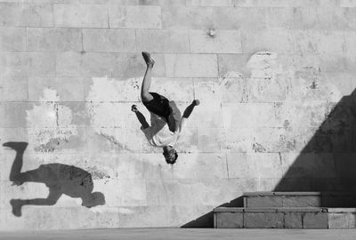 Low angle view of man jumping against wall parkor action in ab va atash park in iran