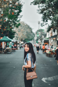 Portrait of a smiling young woman in city