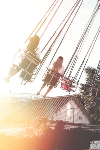 Low angle view of chain swing ride against sky