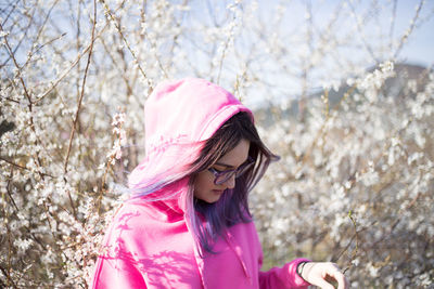 Portrait of woman with pink flowers on tree