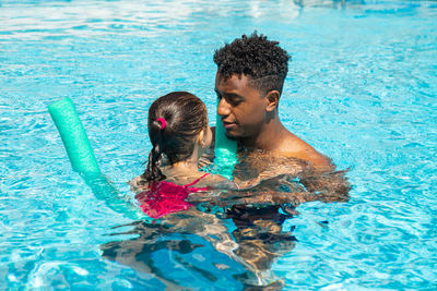 Father and daughter having fun in pool