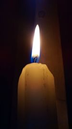 Lit candle in dark room