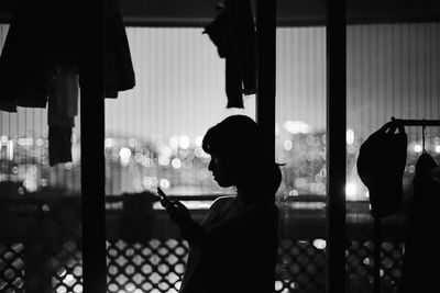 Close-up of silhouette man using mobile phone