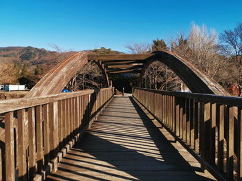 Wooden footbridge against clear sky