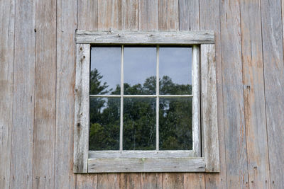 Old weathered wooden barn window reflection