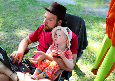 Rear view of two people sitting in park