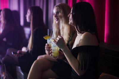 Rear view of woman drinking glass