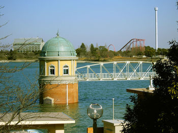 Building by river against sky