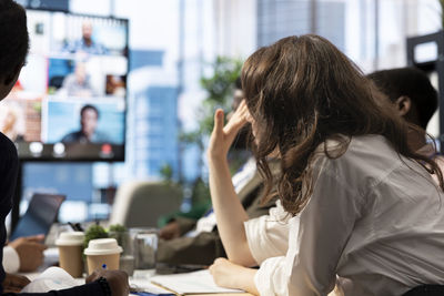 Side view of woman using mobile phone at office