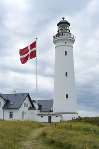 Lighthouse amidst buildings against sky