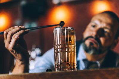 Bartender preparing cocktail at counter in bar