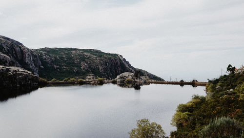 Scenic view of river by mountain against sky