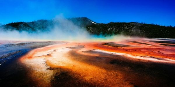 Idyllic shot of hot spring with smoke at yellowstone national park against sky