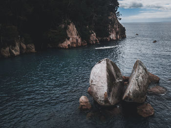 Rock formation in sea against sky