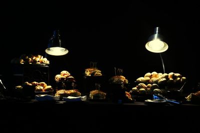 Illuminated candles on table against black background
