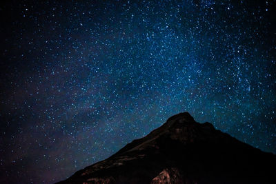 Low angle view of mountain against sky at night