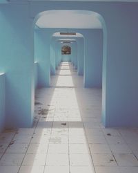 Empty corridor amidst blue arches