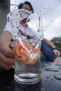 Midsection of person holding drink on table