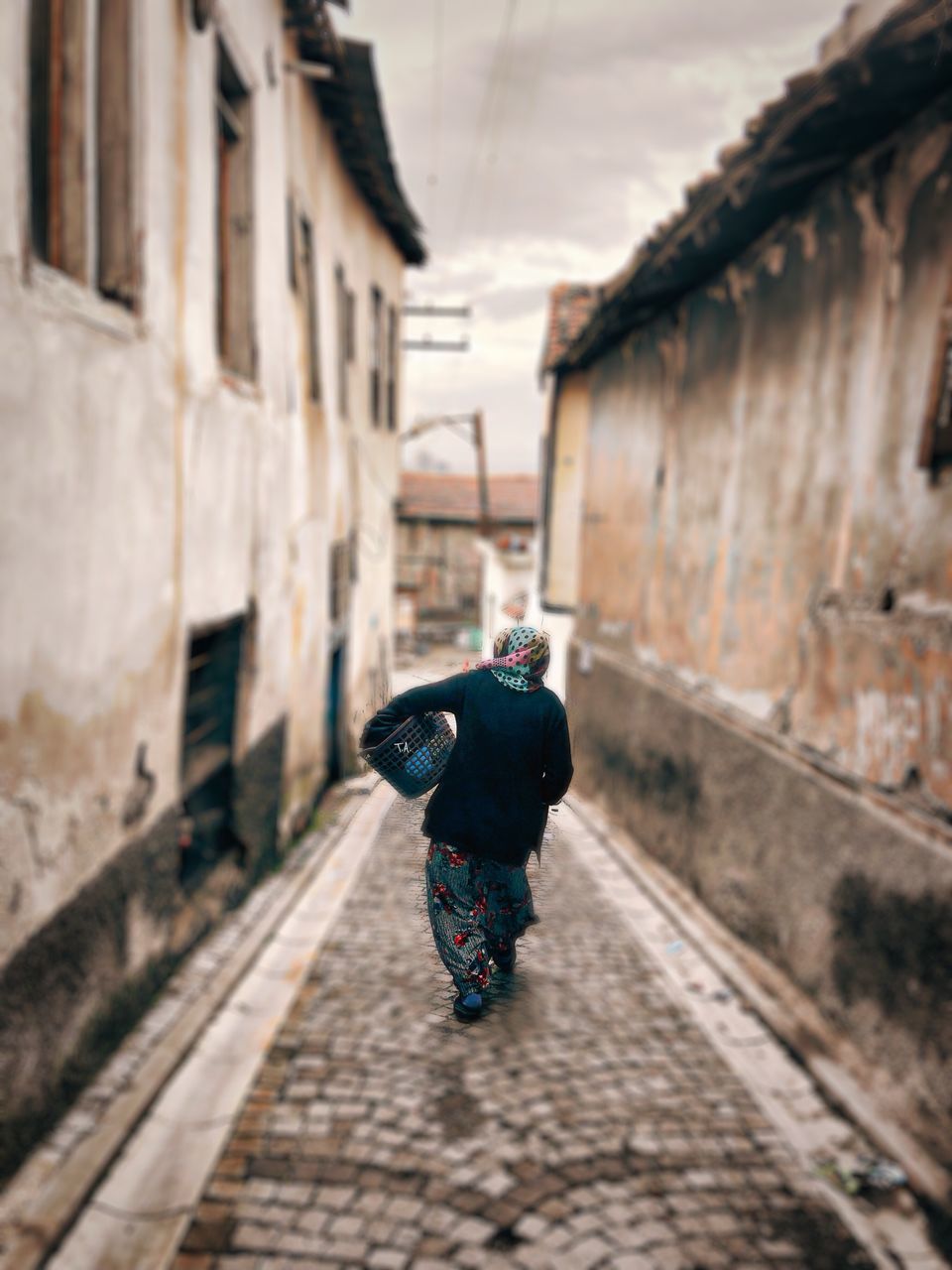 architecture, built structure, building exterior, one person, day, building, full length, focus on foreground, one animal, real people, wall, wall - building feature, house, nature, outdoors, clothing, animal wildlife, footpath