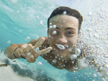 Portrait of young man swimming in sea