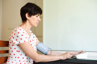 Side view of mature woman using medical equipment at home