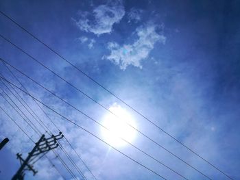 Low angle view of electricity pylon against blue sky