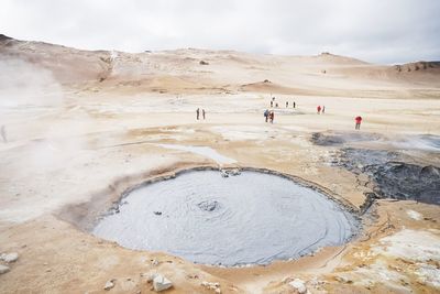People on shore against sky