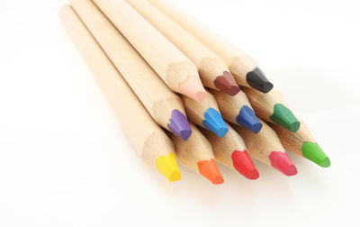 Close-up of multi colored pencils against white background