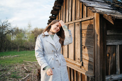 Girl with long hair in a grey trench coat outdoors in spring