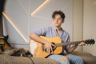 Young man playing guitar at home