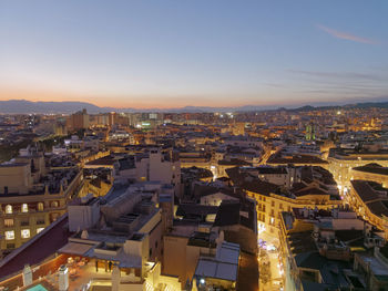 High angle view of illuminated cityscape against sky at dusk