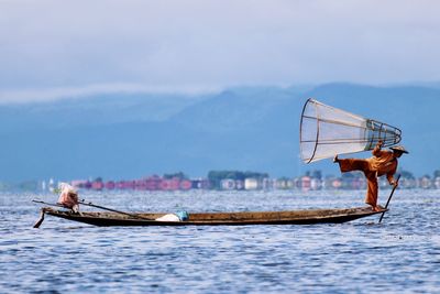 Man balancing on boat in sea